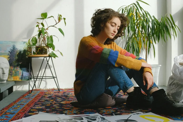En la foto sale una mujer con mirada pensativa sentada en el suelo