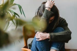Mujer con dolor acompañada en la imagen de una planta
