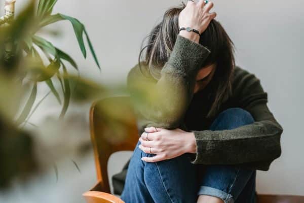 Mujer con dolor acompañada en la imagen de una planta